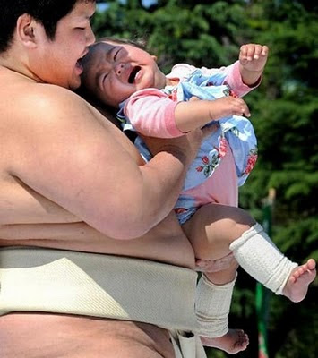 Sumo yunior menggerakan tubuh bayi ke atas bawah, membuat bayi menangis kekejer.