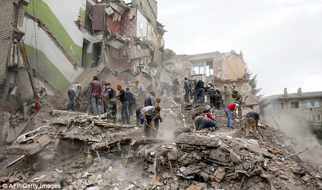 Rescuers search for bodies after an airstrike destroyed an apartment complex in Eastern Ukraine killing 11