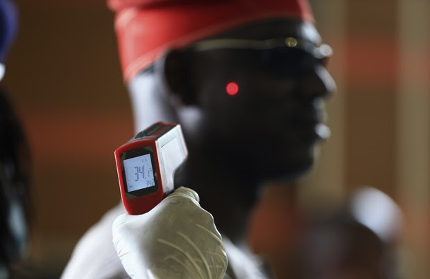  Homem tem a temperatura aferida em termômetro digital no aeroporto internacional de Abuja, na Nigéria   (Foto: Reuters/Afolabi Sotunde)