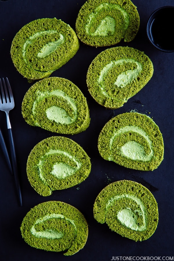 Slices of matcha roll cakes on the black cutting board.