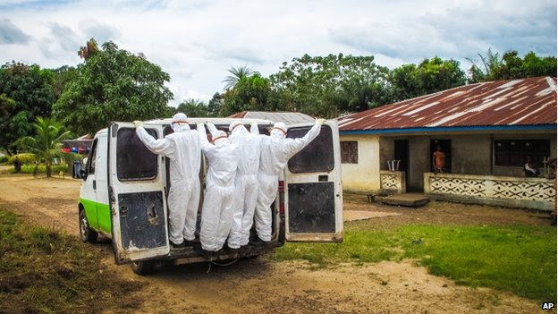 Health workers transport the body of a person suspected to have died (out of shot) of the Ebola  on the outskirts of Freetown, Sierra Leone, on Tuesday 21 October 2014. 