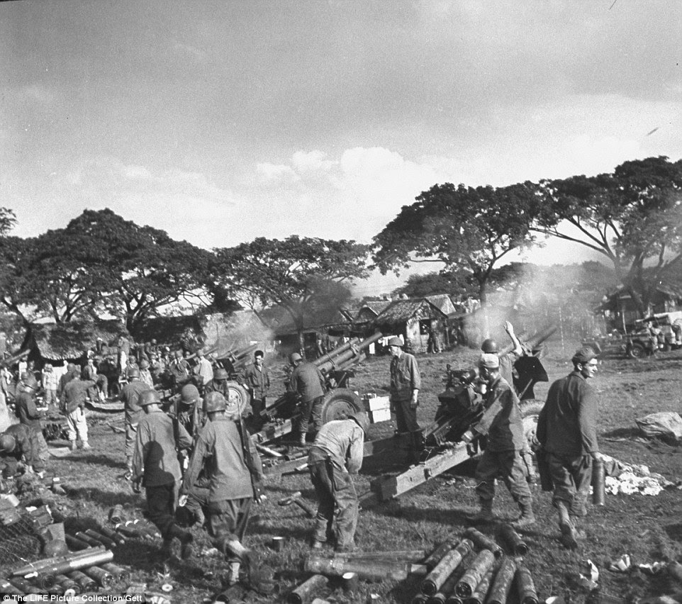 War: American artillery crews firing on Japanese positions from the grounds of the recently liberated Santo Tomas University during the Battle for Manila. ended the three-year Japanese military occupation in the Philippines