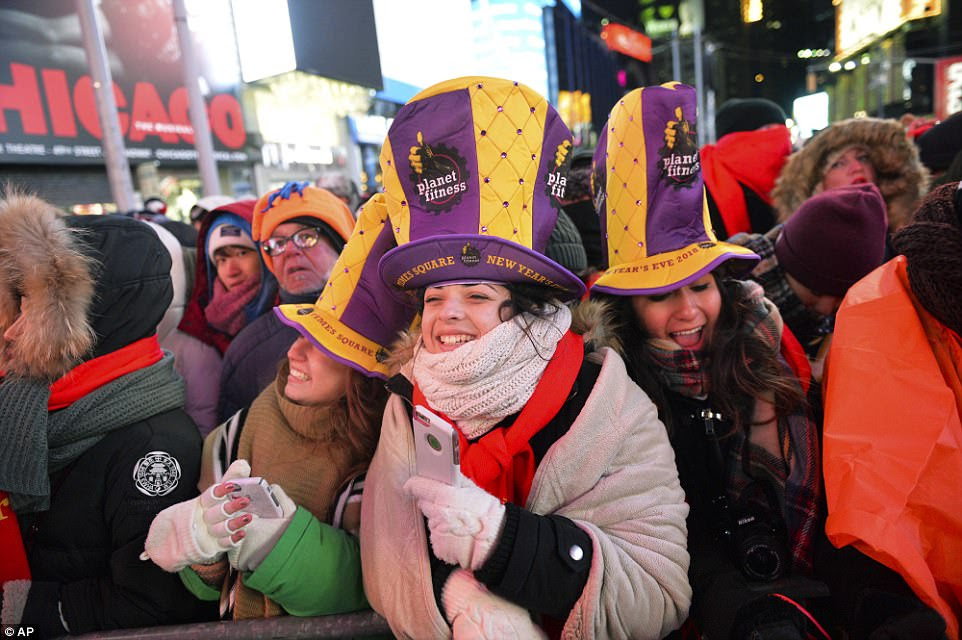 Revelers wearing purple and yellow Planet Fitness hats gather in Times Square during New Year's Eve celebrations on Sunday