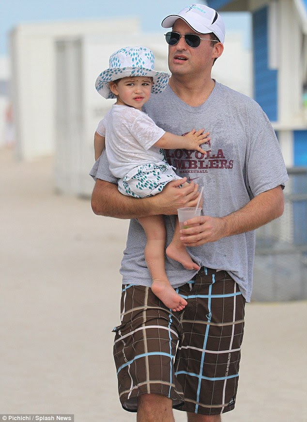 Casual daddy: Scott looked more thrown together in a casual gray T-shirt and board shorts