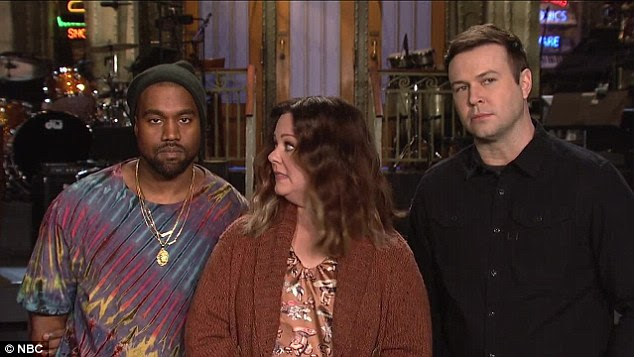 Not cracking: The rapper stood stony-faced next to the Melissa and Taran, while the Bridesmaids actress introduced herself and the forthcoming episode - his seventh appearance from Studio 8H