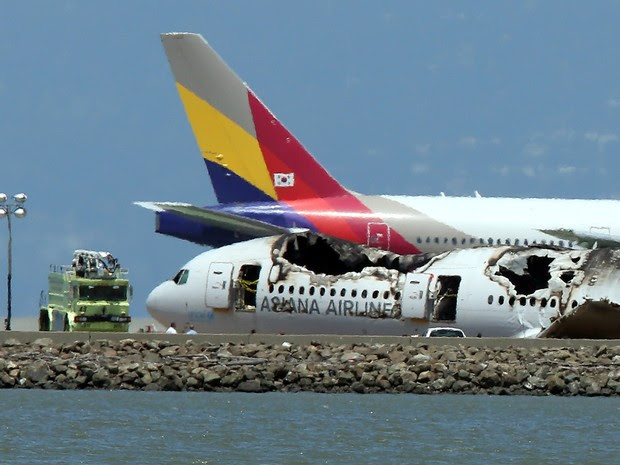 Aeronave da Asiana Airlines passa ao lado do Boeing 777 que se acidentou no dia 6 de julho no Aeroporto de San Francisco. (Foto: Justin Sullivan/Getty Images/AFP)