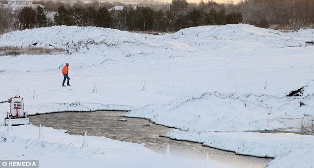 Alien landscape: A construction worker makes his way to work over fields in West Lothian