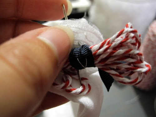 Stitch twine bow onto flower
