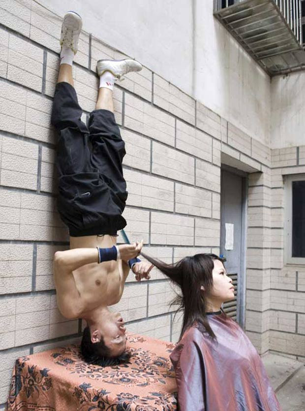 Chinês fica de ponta-cabeça para cortar cabelo na China. (Foto: Reuters)