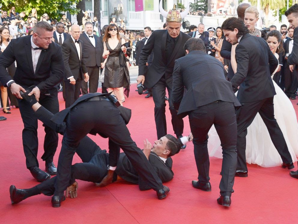 PHOTO: A man is held by security after invading the read carpet at the How To Train Your Dragon 2 premiere during the 67th Annual Cannes Film Festival on May 16, 2014 in Cannes, France.