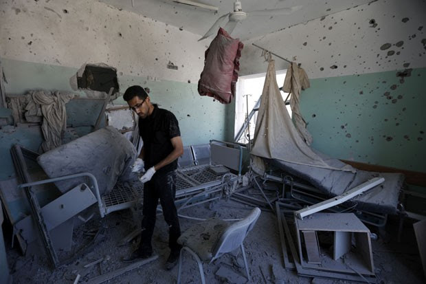 Funcionário palestino inspeciona hospital que foi atingido por bombardeio nesta segunda-feira (21) na Faixa de Gaza; quatro pessoas morreram (Foto: Mohammed Abed/AFP)