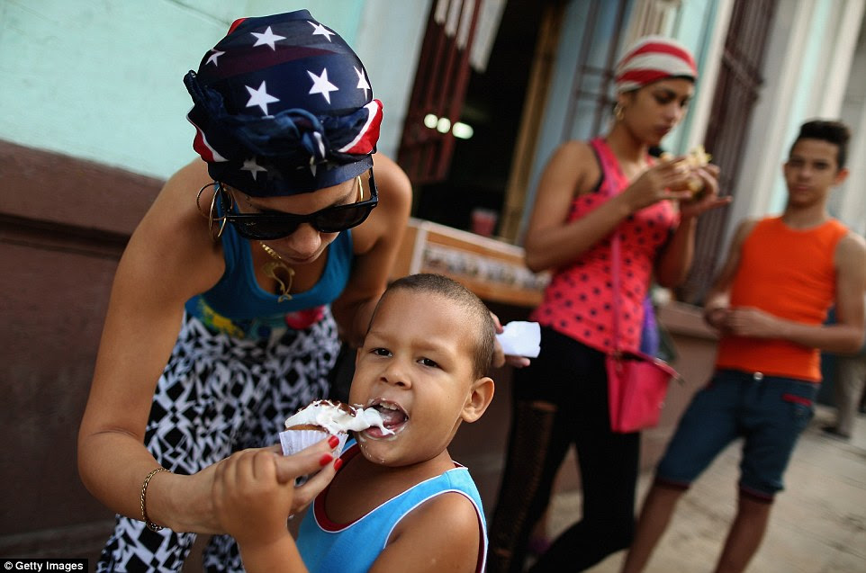 A woman, Gydis Ricardo Vargas (left) feeds her son Wisin some ice cream in the Vedado district of Havana