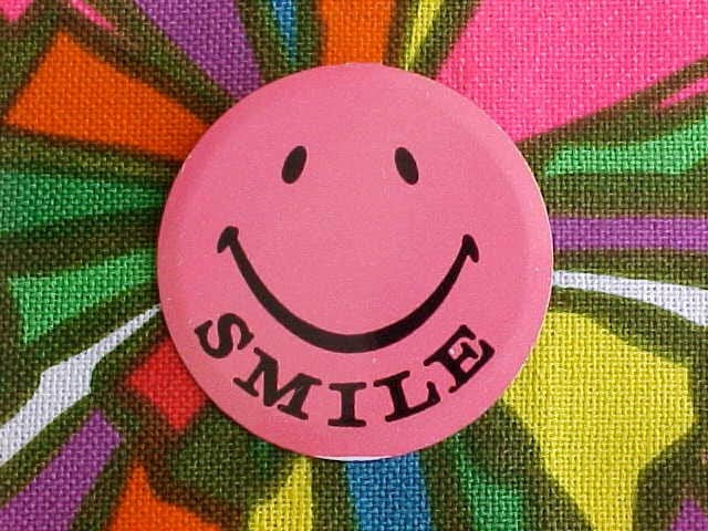 Flashing pink smile face badge