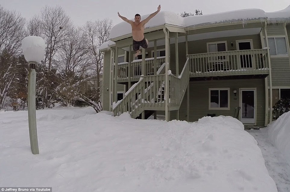 Risky leap: Other striking pictures that the sub-zero temperatures, snow and ice have produced include thrill-seekers 'diving' into snow piles from windows and balconies (pictured) as part of what has been dubbed the 'Boston Blizzard Challenge'. The challenge has been condemned by the city's Mayor, Martin Walsh, who said in a press conference: 'This isn’t Loon Mountain. This is the city of Boston'