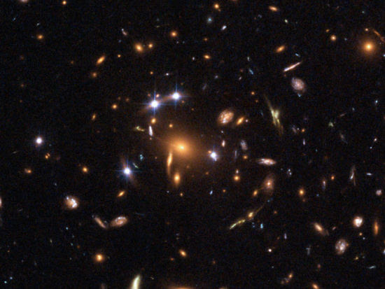 这是一个引力透镜效应的实例：位于图像中央位置的一个大质量星系群具有强大引力，导致其后方远处星系传来的光线被完全并呈现多重假象。在这一案例中，充当前景引力透镜体的星系群编号为SDSS J1004+4112，位于小狮座方向，距离地球约70亿光年。图像由哈勃空间望远镜拍摄