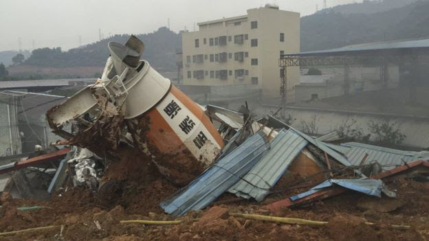 A damaged vehicle is seen among the debris at the site of a landslide at an industrial park in Shenzhen, Guangdong province, China, December 20, 2015.