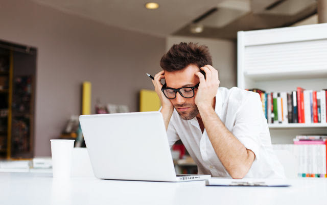 Tired student or businessman working with laptop in the office