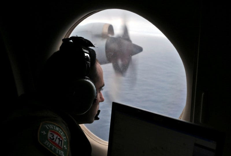 Flight officer Rayan Gharazeddine looks out of a Royal Australian Air Force (RAAF) AP-3C Orion as it flies over the southern Indian Ocean during the search for missing Malaysian Airlines flight MH370 March 22, 2014.  REUTERS/Rob Griffith/Pool/File Photo 