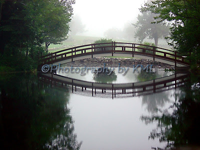 a small foot bridge in the early morning fog