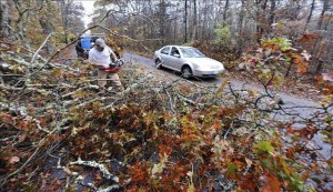 Un hombre corta ramas de árboles caídos tras el paso del huracán Sandy por Westport en Massachusetts (Estados Unidos). EFE.