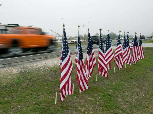 Onze bandeiras fincadas em estrada homenageiam grupo de militares mortos após queda de helicóptero na Flórida. (Foto: Michael Spooneybarger / Reuters)