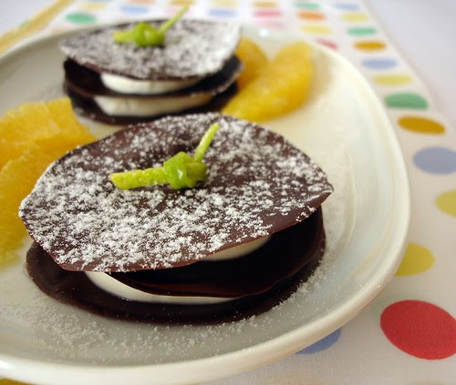 Chocolate discs with orange cream and marinated oranges