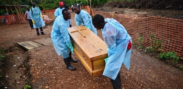 Coveiros usam luvas e roupas de proteção para carregar corpos das vítimas de ebola em Serra Leoa
