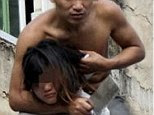  The topless man gestures to the police he holds his girlfriend hostage with a knife atop a residential house in Sanya, Hainan province January 20, 2014 