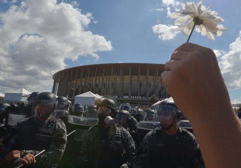 Manifestantes levantam flores para mostrar o intuito pacífico do protesto contra os gastos públicos com a Copa do Mundo em Brasília, 2013