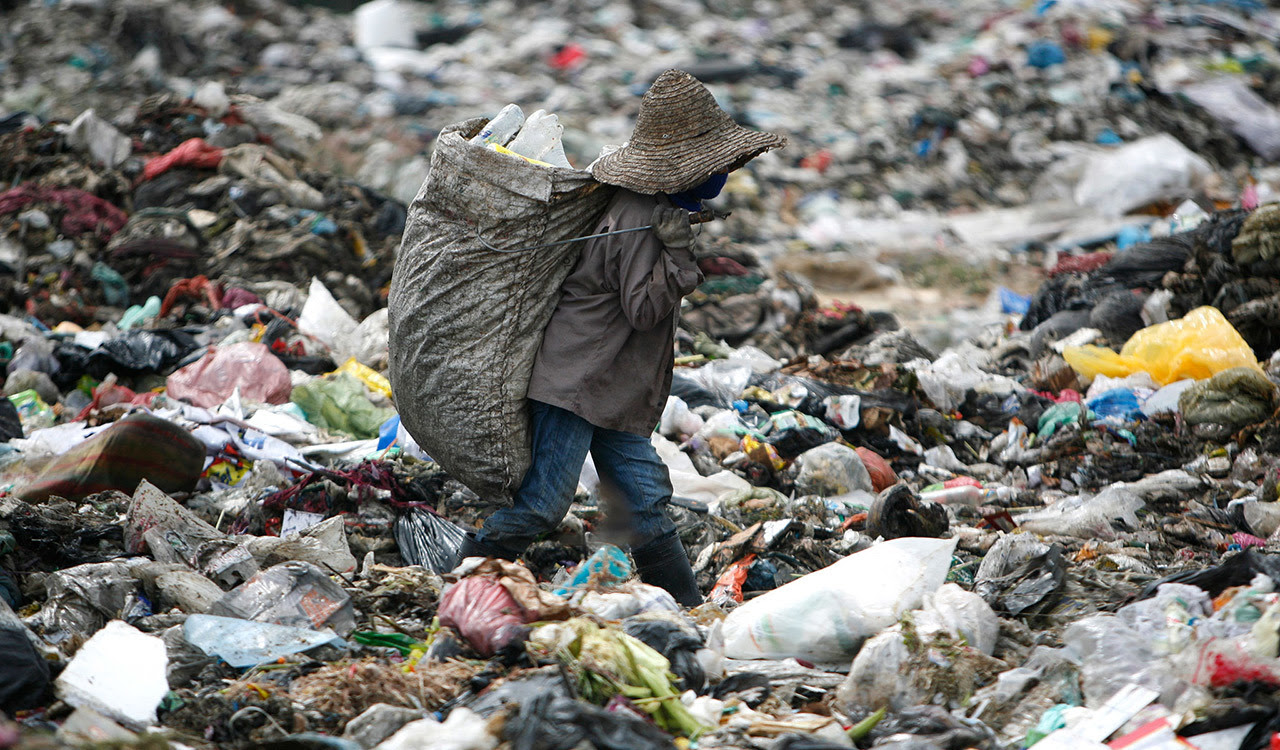 A man looks for plastic to recycle at a garbage site in Malaysia.