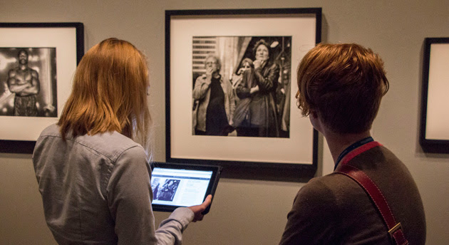 A guest learns about a Smithsonian photo on an iPad