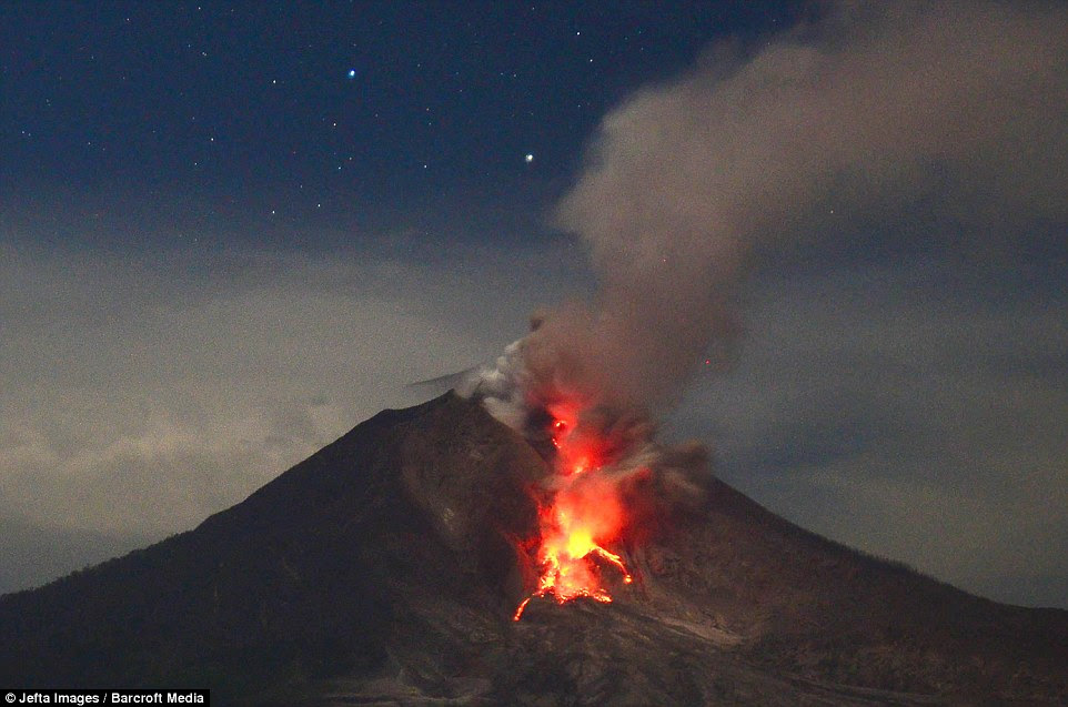 Lava continues to run down the Mount Sinabung crater, as seen from Tiga Pancur - it is still emitting volcanic ash, smoke and rock
