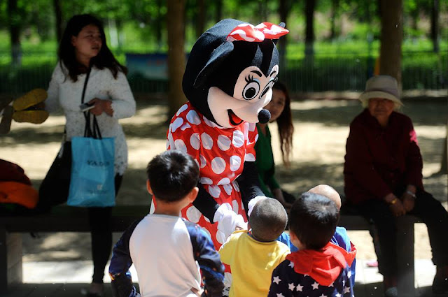 Old woman wears Mickey Mouse costume to pay relative's medical bills