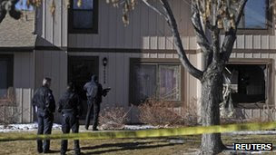 Police survey the outside of a townhouse complex following a shooting incident in Aurora, Colorado.
