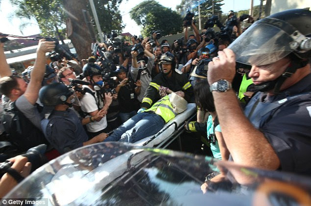 Injured: CNN producer Barbara Arvanitidis is rushed away on a stretcher after breaking her arm