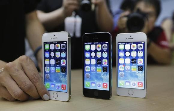 A staff member sets up the new iPhone 5Ss for a display picture at Apple Inc's announcement event in Beijing, September 11, 2013.  REUTERS/Jason Lee