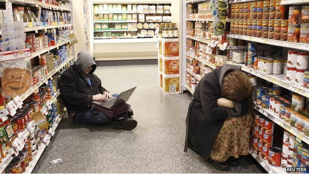 People rest in the aisle of a Publix grocery store after being stranded due to a snow storm in Atlanta, Georgia, on 29 January 2014