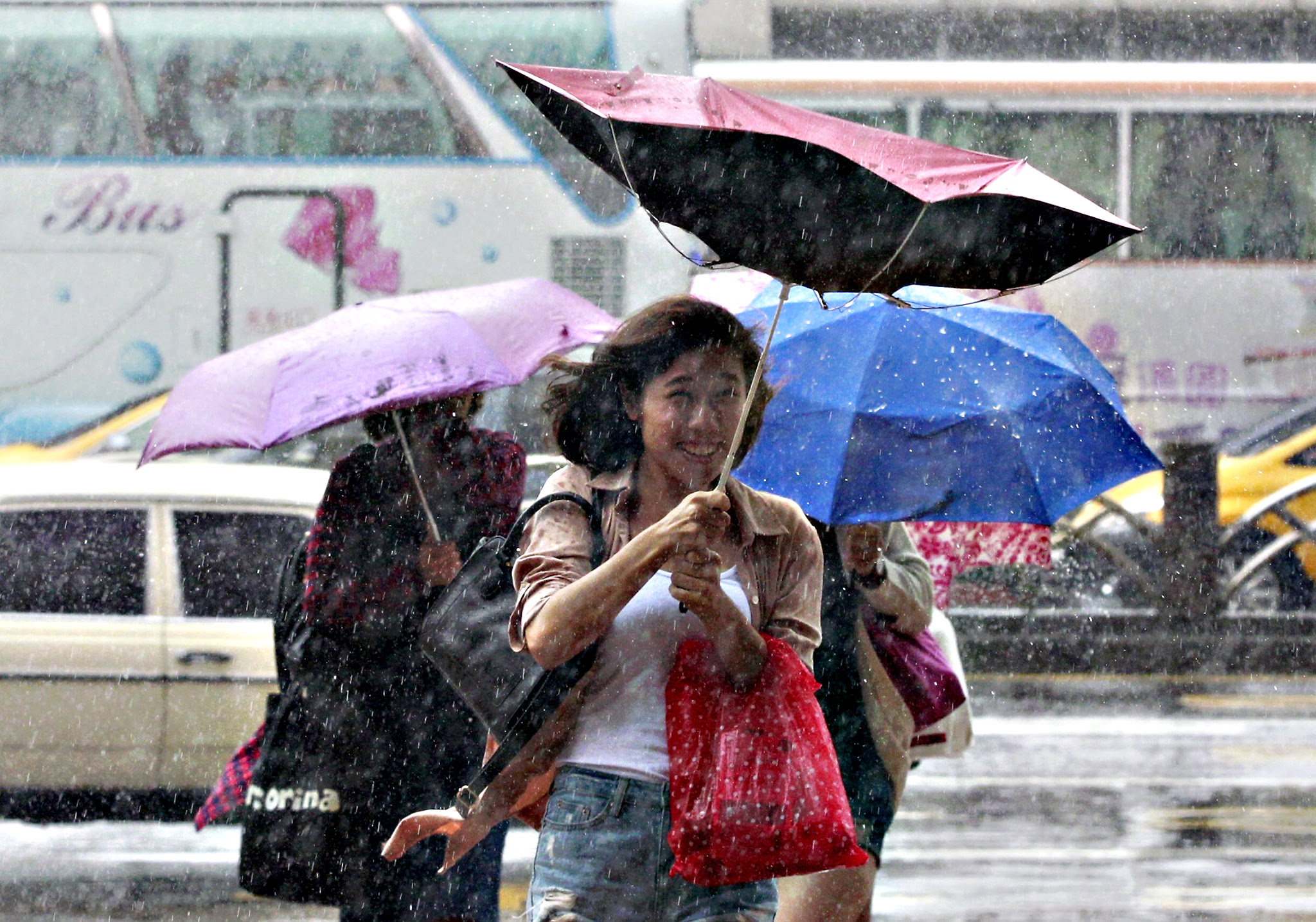 People hold their umbrellas while walking against strong winds caused by Typhoon Dujuan in Taipei, Taiwan, on Monday