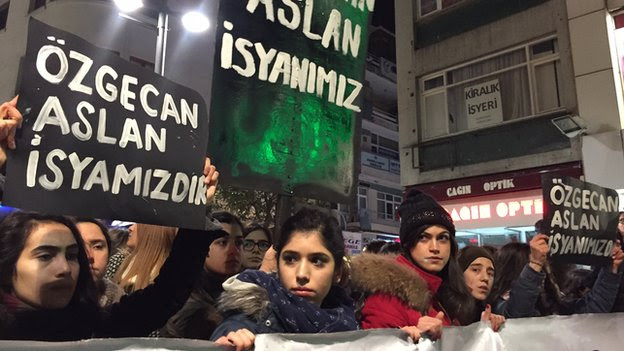 Women hold banners reading 