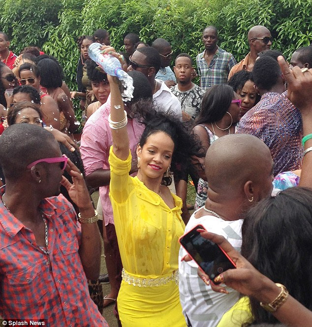 Molhado e selvagem: Rihanna usava uma saia amarela e camisa para a festa