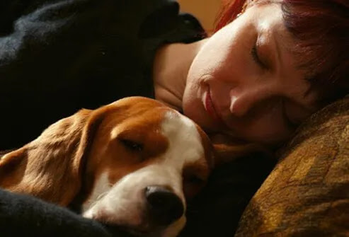 Woman sleeping with her dog.