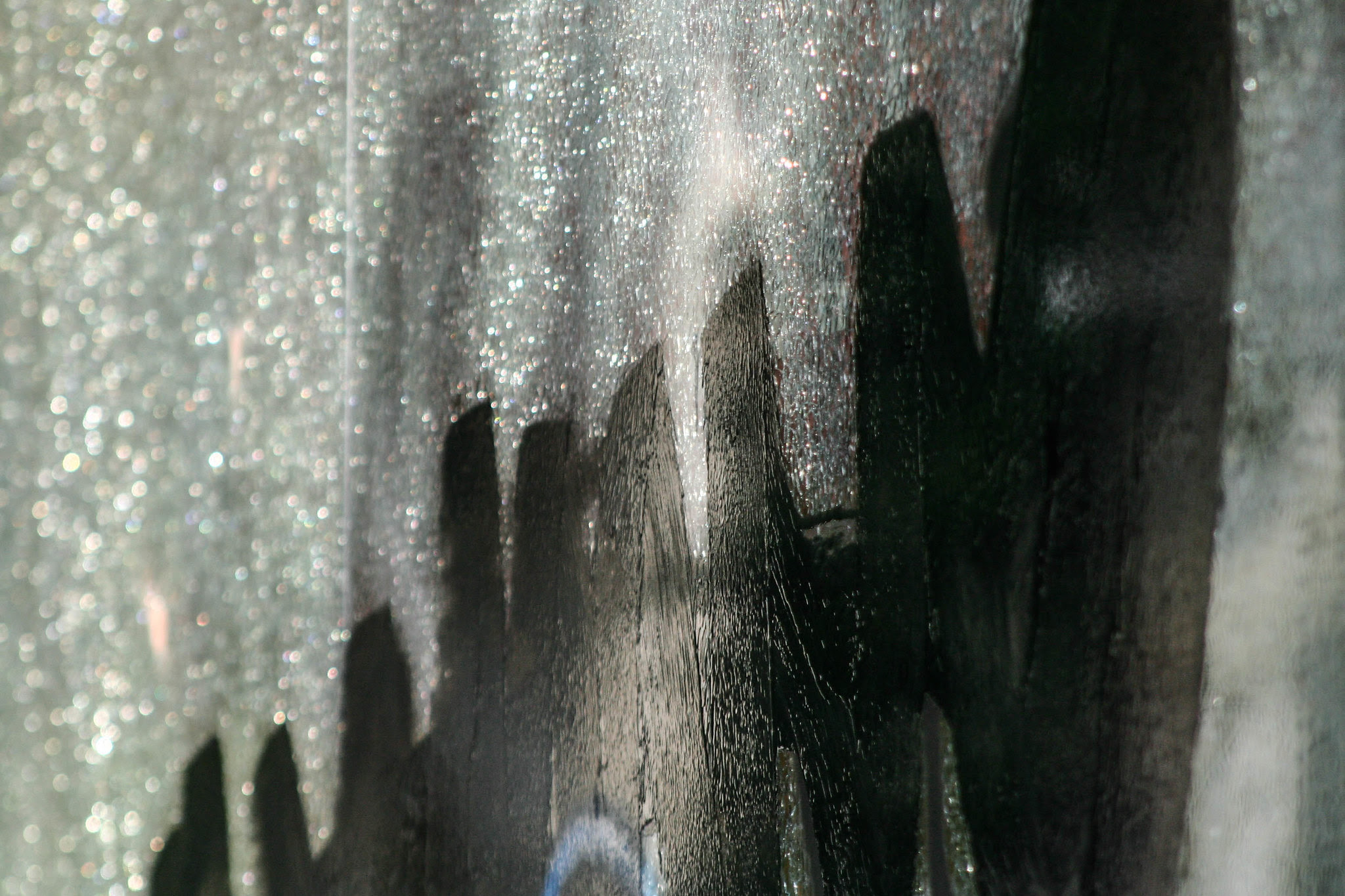 Paint obscuring graffiti on shattered billboard.