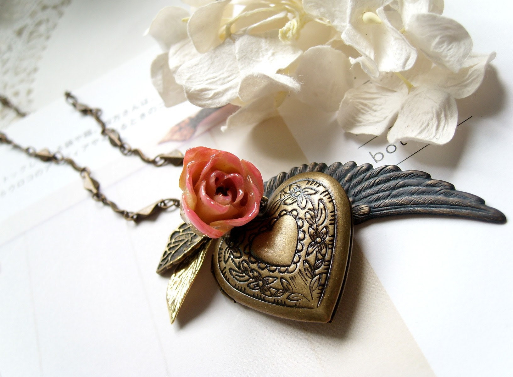 Genova. Gorgeous peach rose bud with heart shaped antiqued brass locket and angel wing and leaves necklace