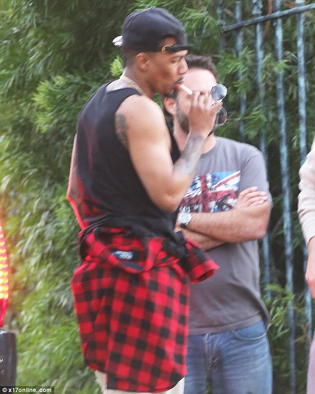 Relaxed: He was dressed casually in a black vest and cream jeans with a checked shirt worn around his waist 