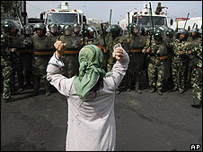 Una mujer uigur protesta frente a un grupo de agentes policiales chinos en Urumqi