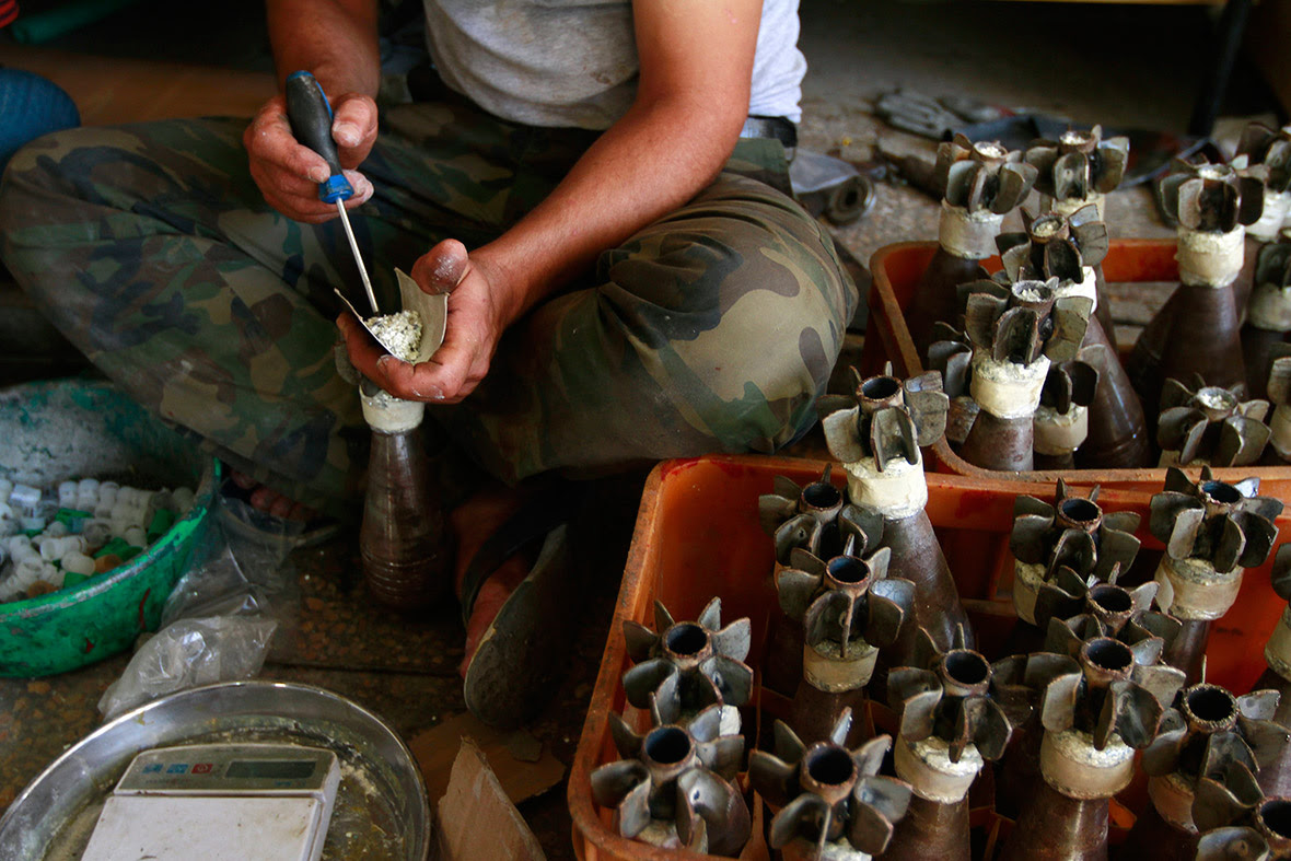 A Free Syrian Army fighter makes improvised mortar shells