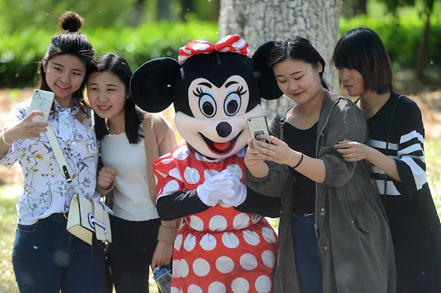 Old woman wears Mickey Mouse costume to pay relative's medical bills
