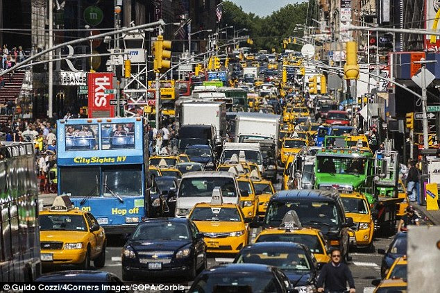 Driverless cars will not only save lives; it's also expected that they will help solve growing traffic issues around the world (stock image of New York shown), by allowing cars to be linked together and travel at the same speed. The IET also thinks they might one day make human-driven taxis redundant as well