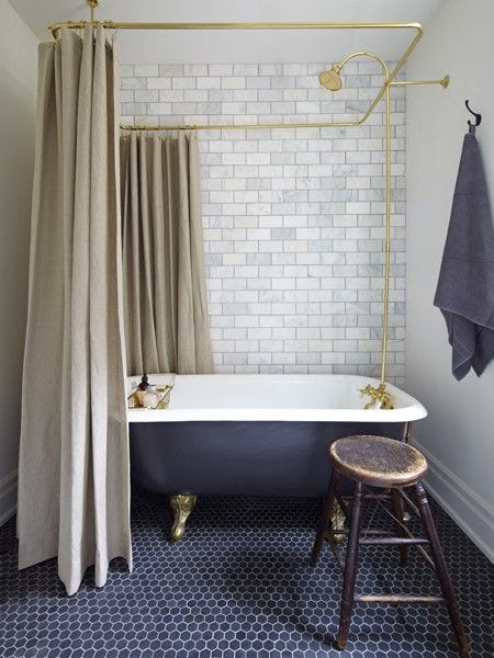 Absolutely love the bath and hexagonal tiled blue floor, the brick feature on the back wall and beige shower curtains work so well together