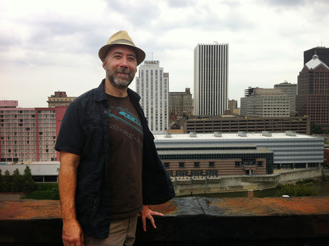 Adam Frank stands atop of the Wilder Building in Rochester, N.Y.